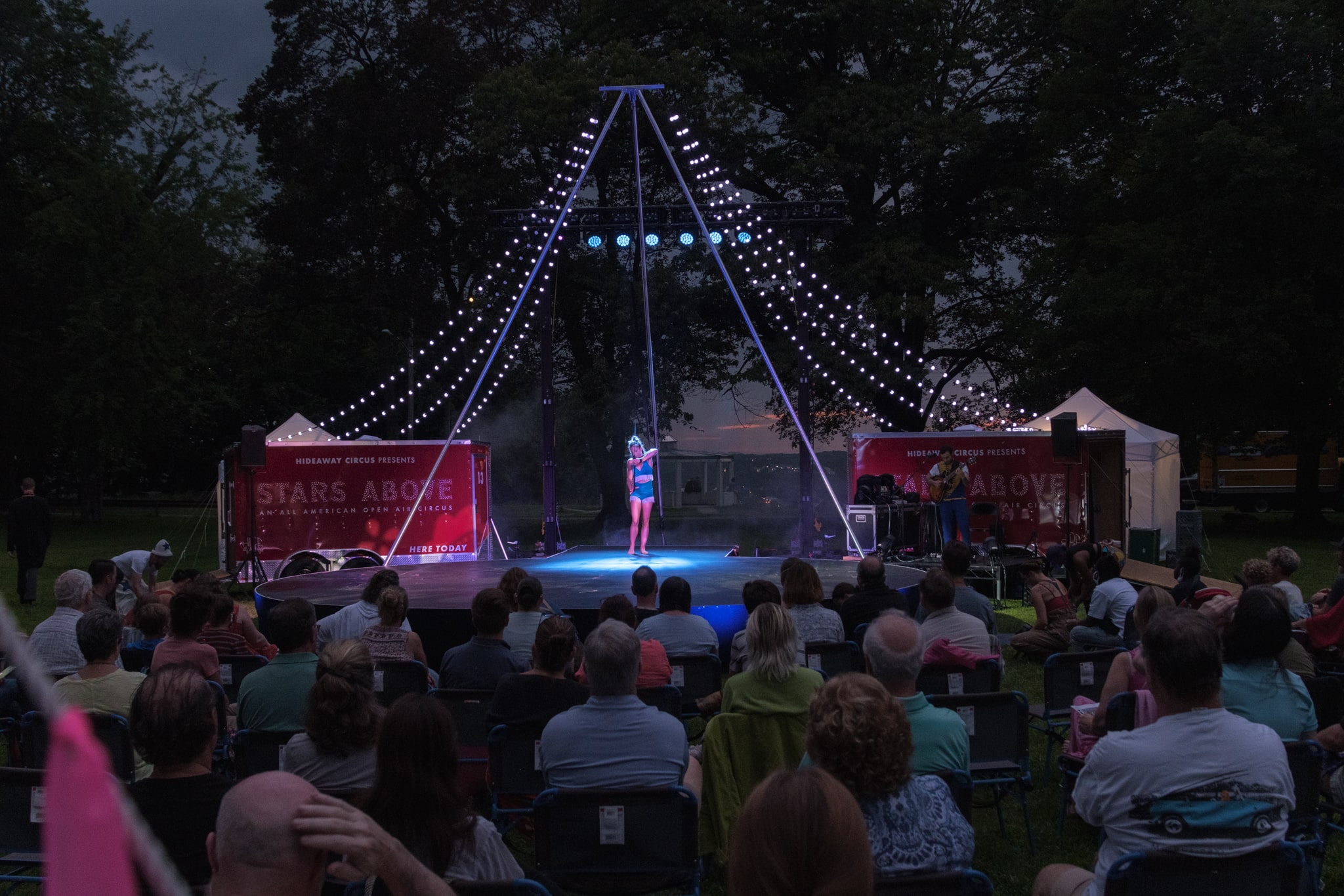 Audience watches aerialist on stage in Prospect Park