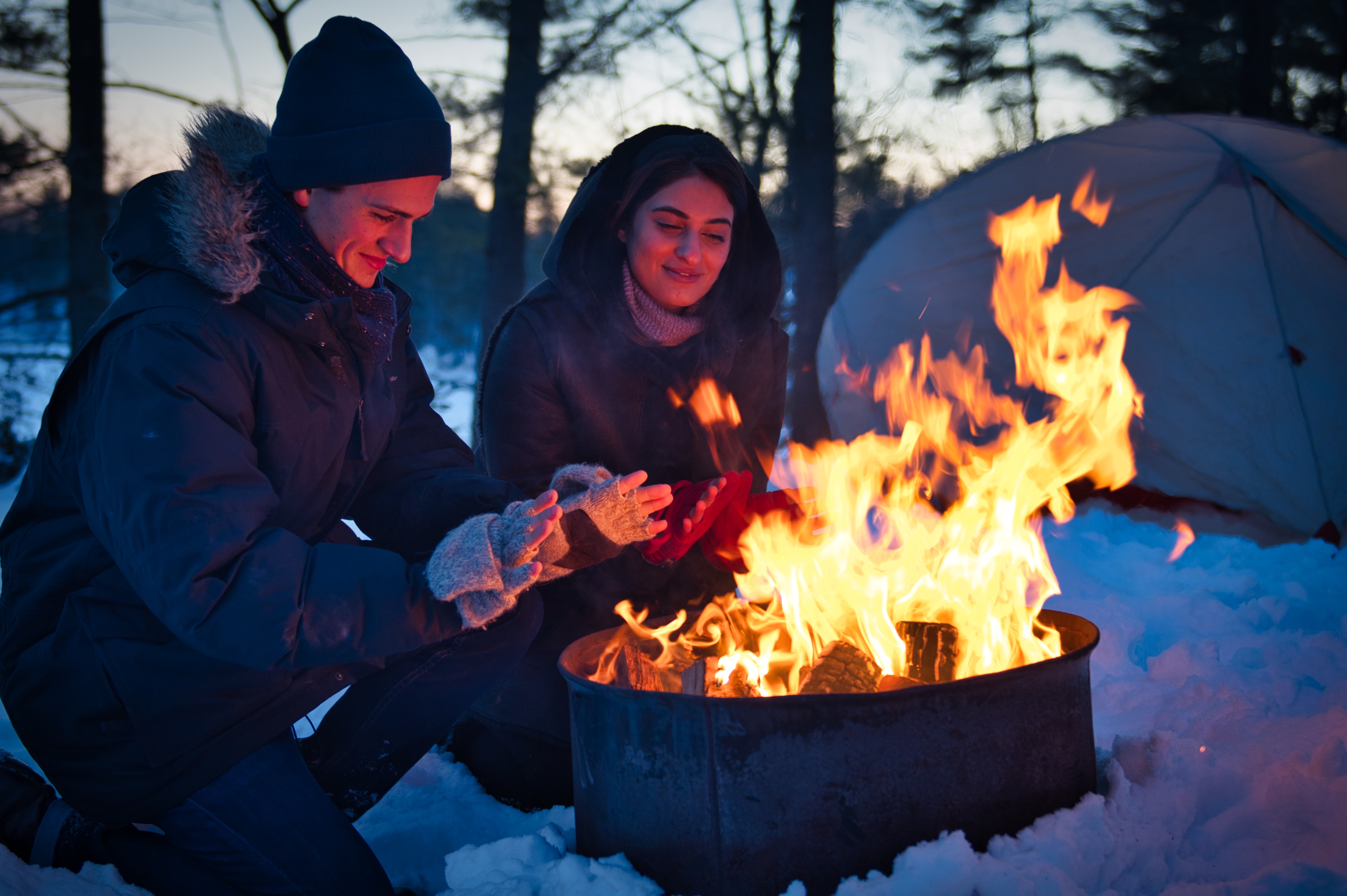 Warming up by the fire while winter camping