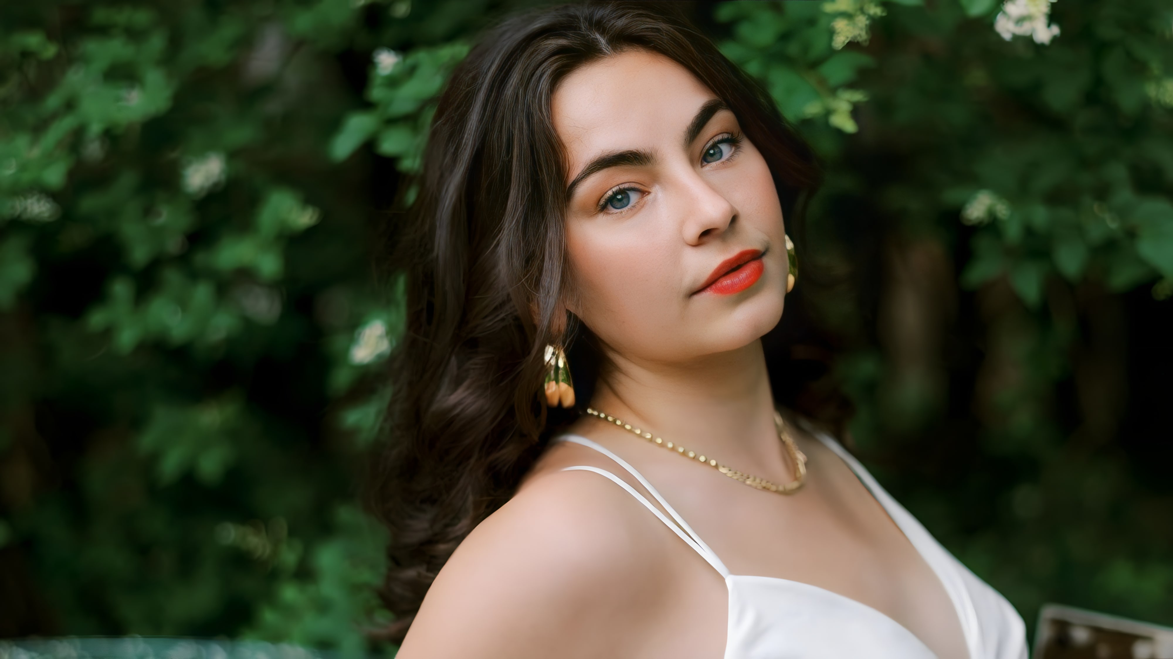 Stella Katherine Cole in white dress against green shrubbery
